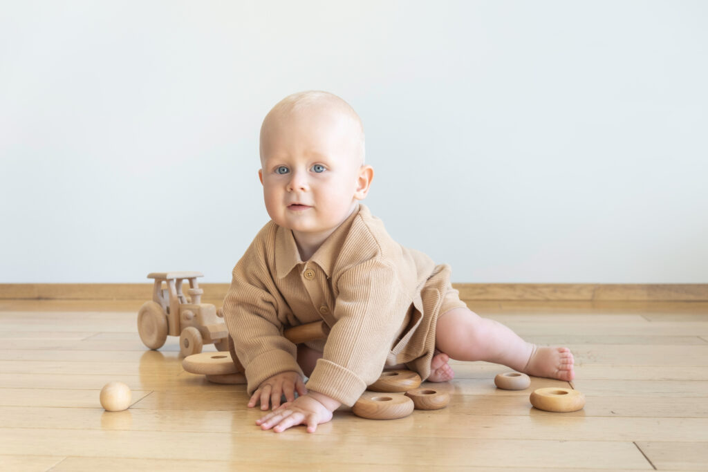 Baby playing with Wooden Toys while sitting on the Floor