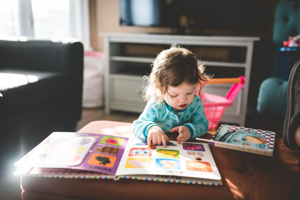 Little girl touching the pages of a Sensory Books