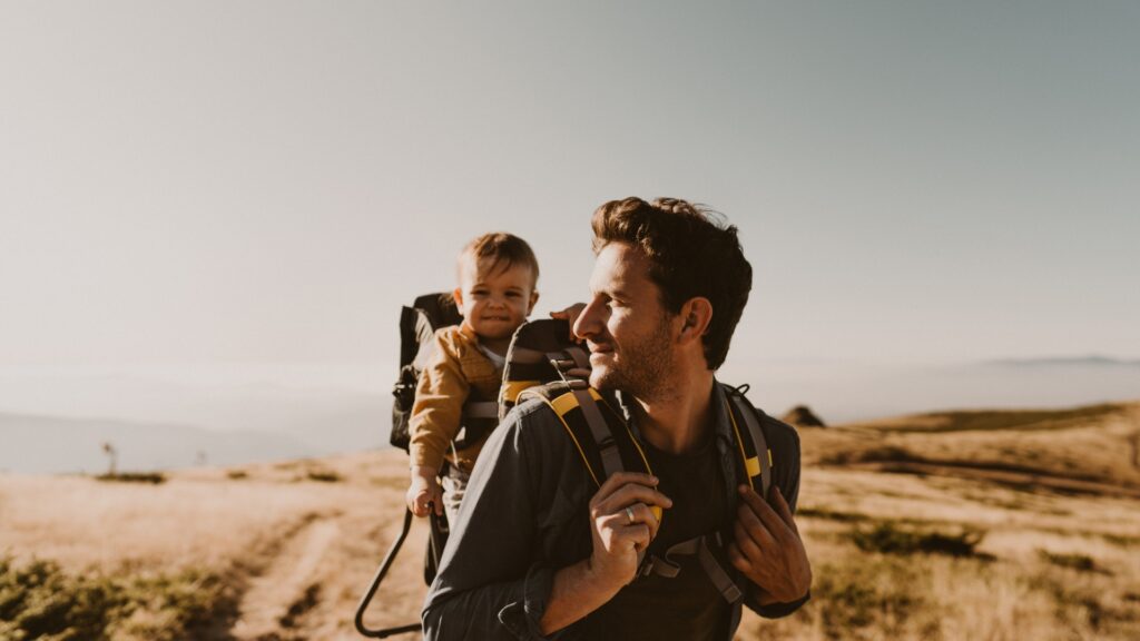 Baby Travel Guide: A Dad with carrying the baby in a baby carrier.