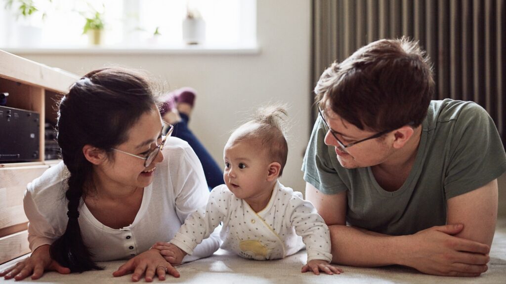 Tummy Time - Baby on her tummy with mom and dad beside her.