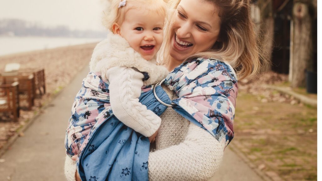 Mother holding her girl in a Ring Sling Baby Carrier