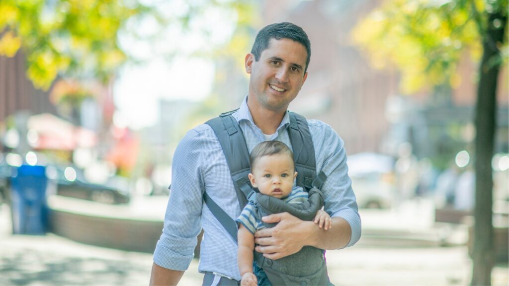 Dad holding his baby in a Soft Structured Baby Carrier