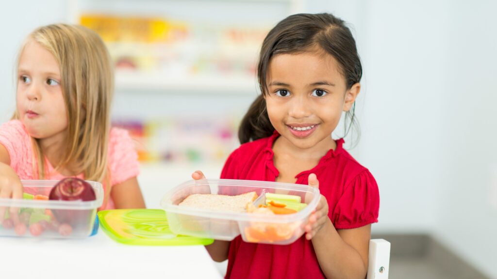 Preschooler showing her lunchbox on the first day of preschool